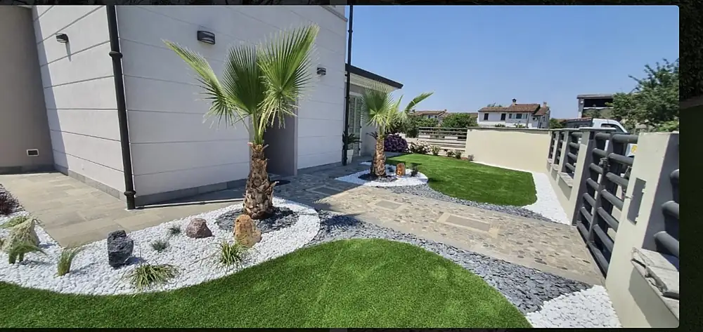 Giardino con palma e prato in erba sintetica