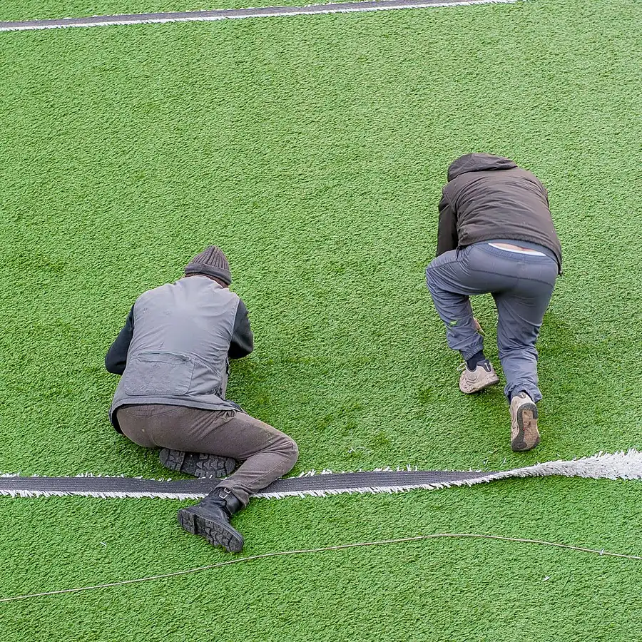 Operatori SB Sport durante la posa e la cucitura del manto sintetico